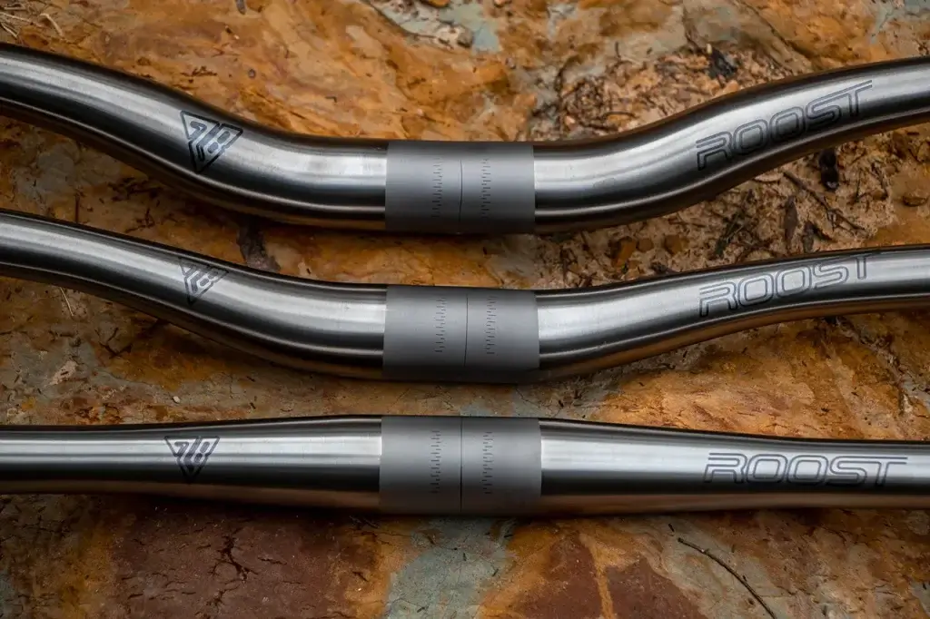 Roost titanium handlebar close up of clamp section and logos - roost bike - roost bike Roost Titanium handlebar close up of clamp section and logos