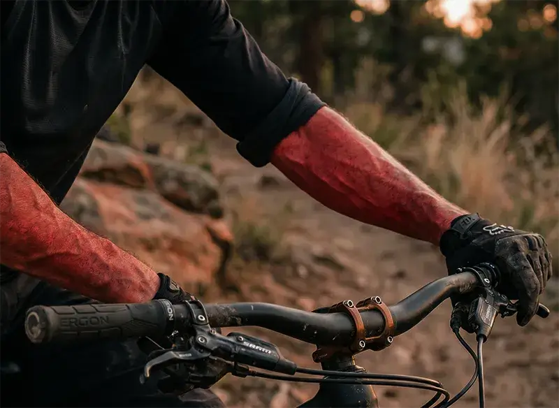 Mountain bike arm pump - roost bike - roost bike Arms of a mountain biker suffering arm pump while gripping a mountain bike handlebar